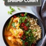 Coconut Shrimp Curry in a bowl with brown rice and text overlay with recipe title for Pinterest.