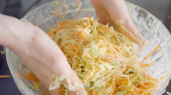 mixing slaw with hands