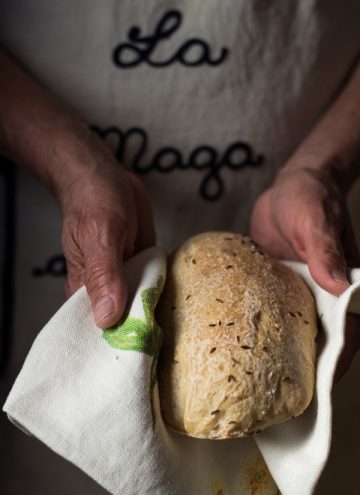 Authentic German Bread held in a kitchen towel in hands