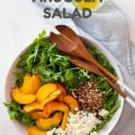 arugula, sliced nectarines, cumbled feta, chopped pecans in a salad bowl and text overlay for pinterest