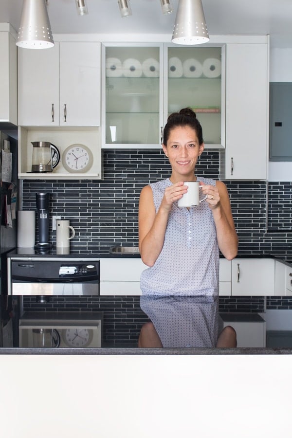 Green Healthy Cooking author in her new shiny kitchen, smiling with a cup in her hands.