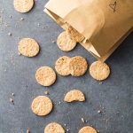 Top view of Homemade Crackers scattered on the counter from a paper bag.