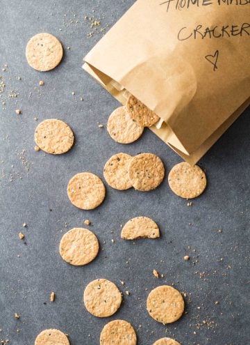 Top view of Homemade Crackers scattered on the counter from a paper bag.