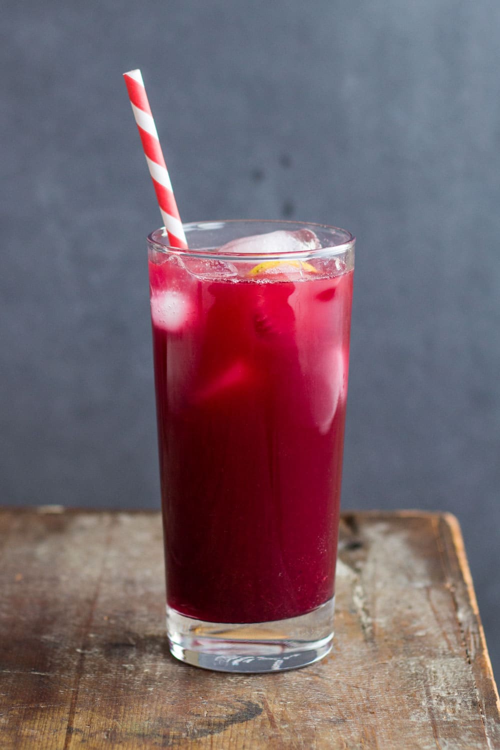 Blood orange lemonade in a glass with a paper straw