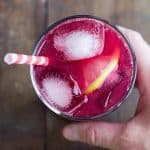 blood orange lemonade with ice cubes and slice of lemon in a glass