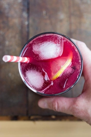 blood orange lemonade with ice cubes and slice of lemon in a glass