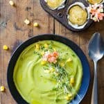 Top view of Vegan Cream Broccoli Soup, a spoon, and cornbread muffins in a muffin tin.