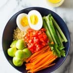 Instant Pot Quinoa Bowl with hard-boiled egg, cucumber, carrots, tomatoes, avocado and lemon tahini dressing.