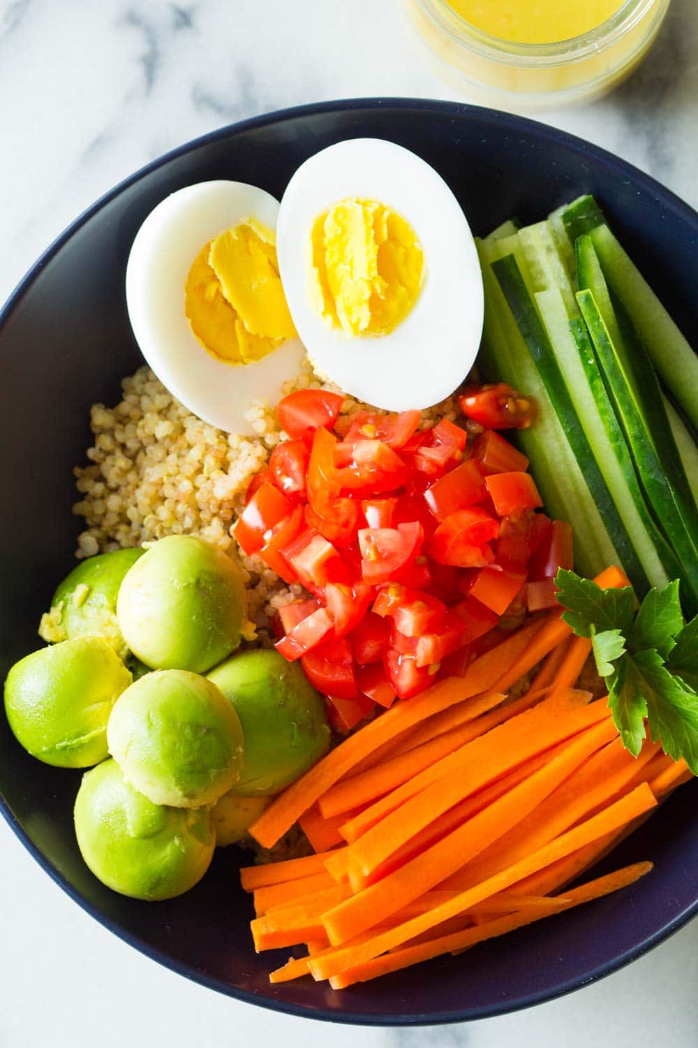 Instant Pot Quinoa Bowl with hard-boiled egg, avocado, carrot, cucumber and tomato