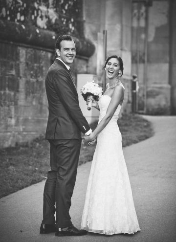 Black and white photo of a couple smiling on their wedding day.