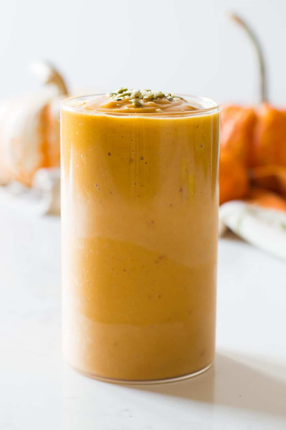 pumpkin smoothie in a tall glass filled to the rim