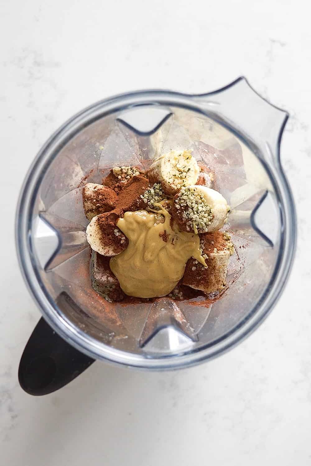 Ingredients for a Healthy Chocolate Peanut Butter Banana Smoothie in a blender.