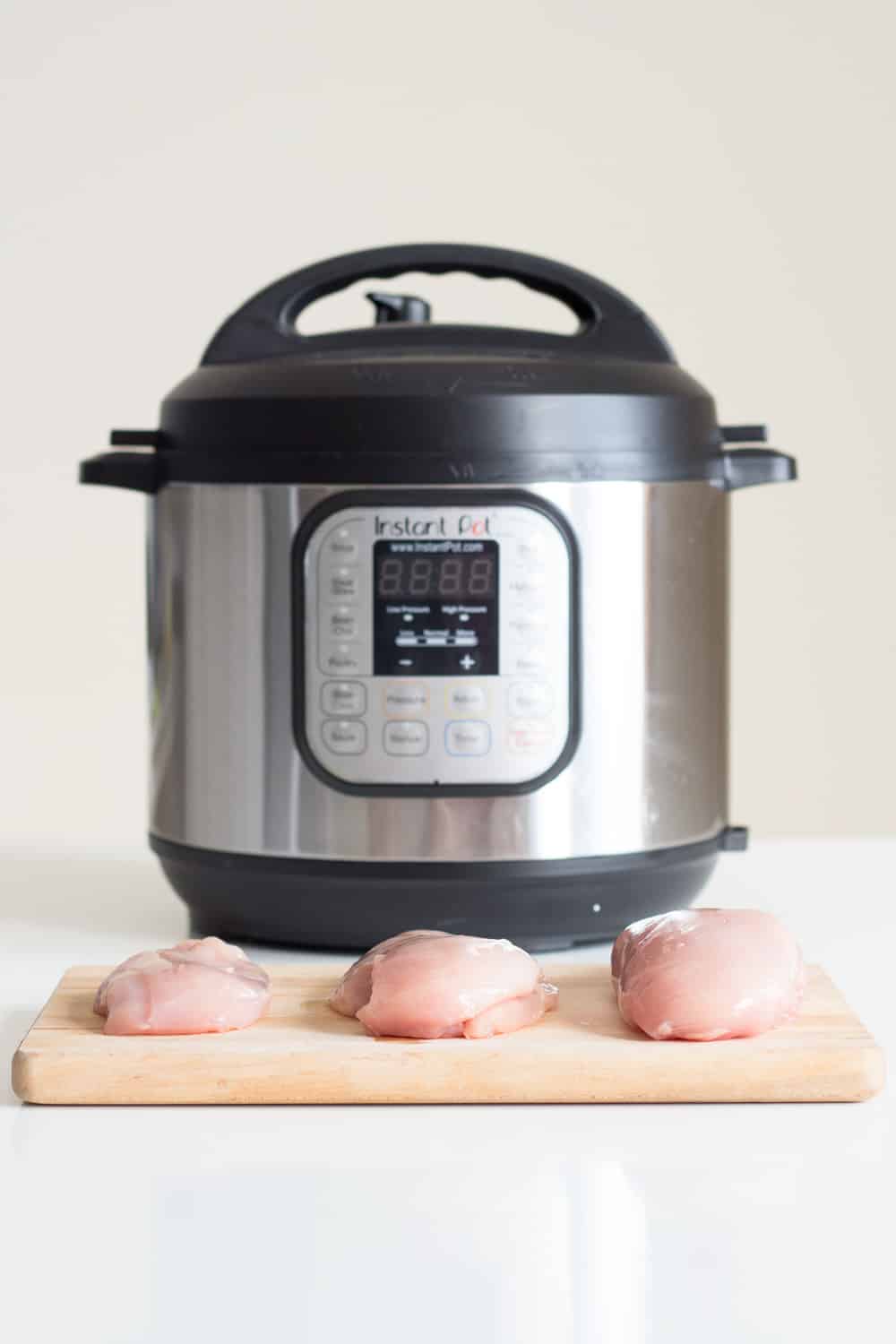 The longest experiment of all times: Instant Pot Chicken. How long to pressure cook a whole chicken, chicken legs, chicken thighs, chicken drumsticks, chicken wings AND chicken breasts. I've got chicken coming out of my ears now! 3 chicken breasts of different size on a cutting board in front of an Instant Pot