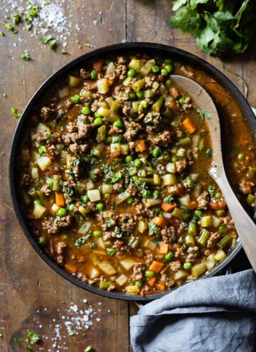 Mexican Picadillo in a large pan on a wooden table.