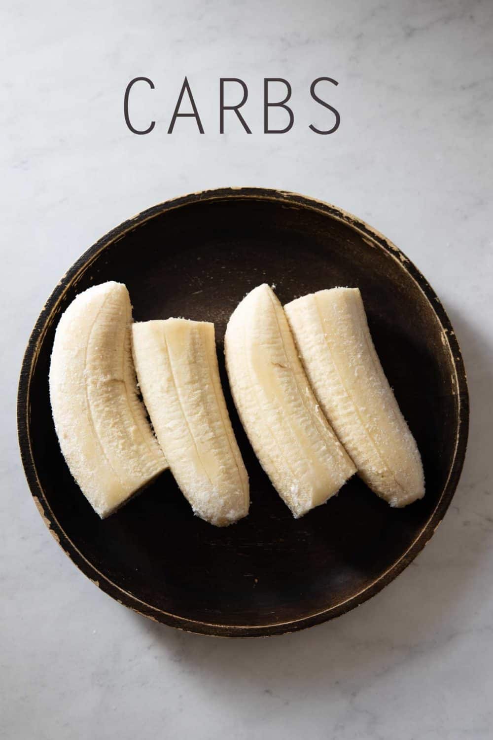 4 banana halves on a brown plate.