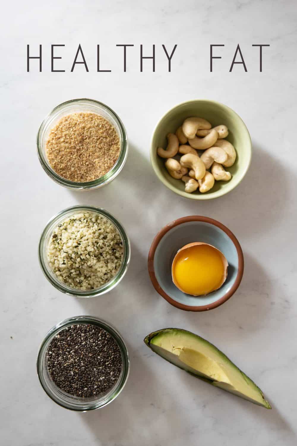 Ground flax seeds, hemp seeds, chia seeds, cashews, an egg yolk, 1/8th avocado in bowls.