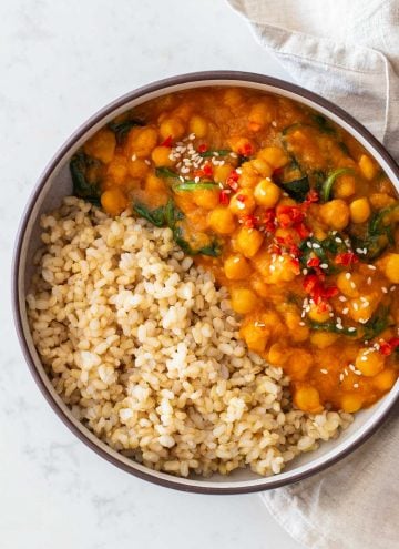 Sweet Potato Curry with chickpeas and baby spinach made in Instant Pot served with brown rice in a round bowl.