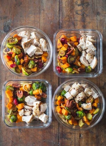 Four Maple Dijon Chicken Meal Prep Bowls on a wooden table.
