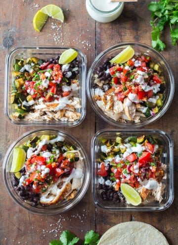 Four Mexican Chicken Meal Prep Containers on a wooden table.