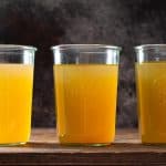 Three glass jars filled with golden chicken bone broth
