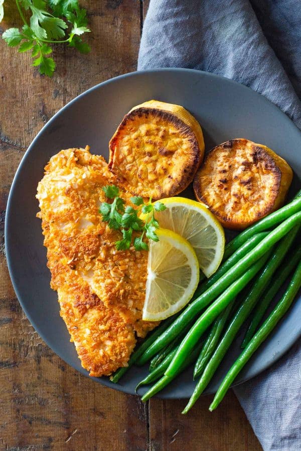 Sole Fish Fillet, sweet potato slices, green beans, and lemon slices on a plate.