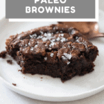 Closeup of a brownie piece on a white plate to show texture on the inside. paleo brownies recipe with text overlay for Pinterest.