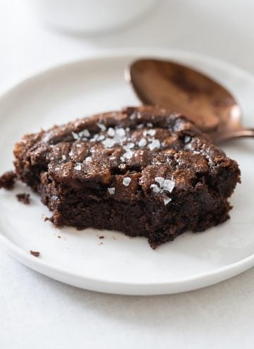 Closeup of a brownie piece on a white plate to show texture on the inside. paleo brownies recipe