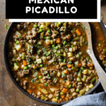 Mexican Picadillo in a large pan on a wooden table with text overlay for Pinterest.