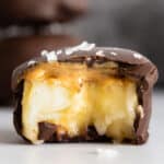 One chocolate covered banana bite bitten into to show inside texture.