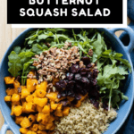 Roasted butternut squash, quinoa, chopped pecans, dried cranberries, arugula in a blue salad bowl with text overlay for Pinterest.