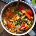 sou with colorful vegetables and ground beef in a small grey bowl.