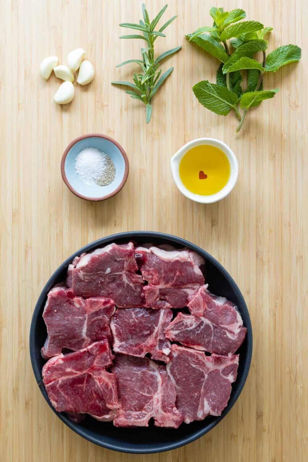Ingredients to make grilled lamb chops laid out on a kitchen counter.