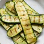 Thinly sliced grilled zucchini on a plate.