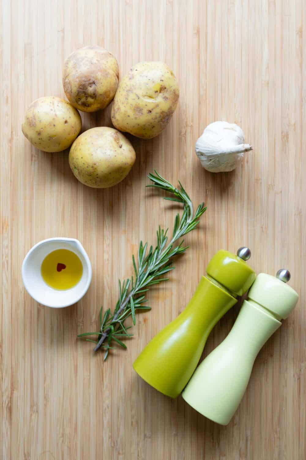 Ingredients for garlic roasted potatoes laid out on a kitchen table.