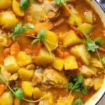 Mauritian Chicken Curry in a white cast iron pot garnished with cilantro.
