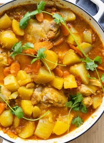 Mauritian Chicken Curry in a white cast iron pot garnished with cilantro.